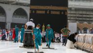 Cleaners wear protective face masks, following the outbreak of the coronavirus, as they swipe the floor at the Kaaba in the Grand mosque in the holy city of Mecca, Saudi Arabia March 3, 2020. REUTERS/Ganoo Essa