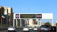 Vehicles pass by a billboard showing precautionary instructions against the COVID-19 coronavirus disease as they drive along a main highway in Kuwait City on March 3, 2020. / AFP / YASSER AL-ZAYYAT 