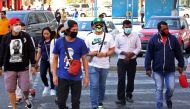 People wearing protective masks cross the street in Kuwait City on March 2, 2020, amid a global outbreak of the novel Coronavirus. / AFP / YASSER AL-ZAYYAT