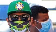 People wearing protective masks are seen on a street in Kuwait City on March 2, 2020, amid a global outbreak of the novel coronavirus. / AFP / YASSER AL-ZAYYAT
 