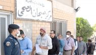 Expatriates are seen in line as they need to take a coronavirus clearance certificate, after returning from vacations, following the outbreak of the virus, at a health clinic in Subhan, Kuwait March 9, 2020. Reuters/Stephanie McGehee