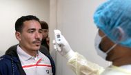 FILE PHOTO: An expatriate (L) takes a coronavirus temperature test, after returning from a vacation, following the outbreak of the virus, at a health clinic in Subhan, Kuwait March 9, 2020. REUTERS/Stephanie McGehee/File Photo