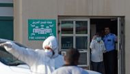 Bahraini policemen seal off a building housing foreign workers in the Salmabad industrial area as a precautionary measure after a resident tested positive for coronavirus (COVID-19), on the outskirts of the capital Manama on March 13, 2020. / AFP / Mazen 