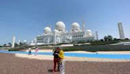 Tourists are seen outside empty Sheikh Zayed Mosque, as Friday prayers were suspended following the spread of the coronavirus disease (COVID-19), in Abu Dhabi, United Arab Emirates, March 20, 2020. Reuters/Satish Kumar
 