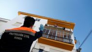 A member of Civil Protection greets a girl on a balcony for her fourth birthday, as they make birthday congratulations to children, during the coronavirus disease (COVID-19) outbreak, in Ronda, southern Spain, April 3, 2020. REUTERS/Jon Nazca