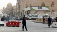 FILE PHOTO: Kuwaiti police officers man a checkpoint at the entrance the town of Jeleeb Al-Shuyoukh, south the capital Kuwait City on April 7, 2020, after the district was put on lockdown. / AFP / YASSER AL-ZAYYAT