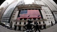 The fearless girl statue and the New York Stock Exchange (NYSE) are pictured on April 20, 2020 at Wall Street in New York City. AFP / Johannes EISELE