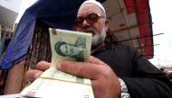 FILE PHOTO: A man buys Iranian rials from a seller of Iranian currency, before the start of the U.S. sanctions on Tehran, in Basra, Iraq November 3, 2018. Picture taken November 3, 2018. REUTERS/Essam al-Sudani