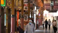 Men wearing face masks, due to the COVID-19 coronavirus pandemic, walk past jewellers' shops at the Dubai Gold Souk in the Gulf emirate on May 13, 2020, as markets re-open amidst an easing of pandemic restrictions. / AFP / Karim Sahib 