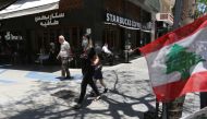 A woman wearing a protective face mask walks past a Starbucks coffee shop in Hamra street, as face masks become compulsory in public as part of the latest measures by authorities to curb the spread of the coronavirus disease (COVID-19), in Beirut, Lebanon