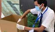 A Lulu Hypermarket staff preparing a carton for delivery.