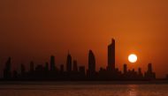 The sun sets behind the skyline of Kuwait City on June 25, 2020. AFP / YASSER AL-ZAYYAT