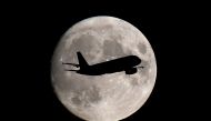 FILE PHOTO: A passenger plane passes in front of the moon as it makes its final landing approach to Heathrow Airport in London, Britain September 12, 2019. REUTERS/Toby Melville/File Photo