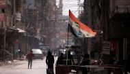 A national flag depicting a picture of Syria's President Bashar al-Assad flutters at a checkpoint in Douma, in the eastern suburbs of Damascus, Syria March 10, 2021. Picture taken March 10, 2021. REUTERS/Omar Sanadiki