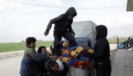 Mohammed Abu Rdan stands on a bag of dishcloths, in front of the cleaning products factory, in northern Aleppo, Syria March 11, 2021. Picture taken March 11, 2021. REUTERS/Mahmoud Hassano