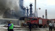 Firefighters try to put out a fire in main Homs refinery, Syria, in this handout picture released on May 9, 2021. 