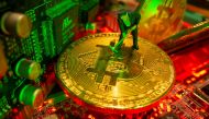 A small toy figure and representations of the virtual currency Bitcoin stand on a motherboard in this picture illustration taken May 20, 2021. REUTERS/Dado Ruvic/Illustration