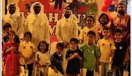 Qatar Rugby, Hockey and Cricket Federation officials pose for a group picture with Afghan children after organising various sports events for them in Doha. The families of the children also attended the events.