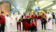 Qatar cyclists and officials pose for a photograph at the Hamad International Airport.