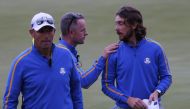 Team Europe's Tommy Fleetwood with Team Europe captain Padraig Harrington and Team Europe vice captain Luke Donald on the 18th green after halving the match during the Four-balls Reuters/Mike Segar