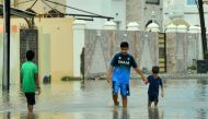 Locals walk on flooded streets caused by Cyclone Shaheen in Al Musanaa, Al Batina region, Oman, October 4, 2021. Oman News Agency/Handout via REUTERS