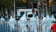 Security personnel in protective suits guard the perimeter of a residential compound locked down after a local outbreak of the coronavirus disease (COVID-19) in Beijing, China, November 11, 2021. Reuters/Thomas Peter/File Photo
 