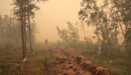 A man digs a control line during the work on extinguishing a forest fire near the village of Magaras in the region of Yakutia, Russia July 17, 2021. REUTERS/Roman Kutukov/File Photo