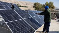 A worker cleans solar panels, which are one of the sustainable energy options that help olive farmers, in Mosul, Iraq February 2, 2022. Picture taken February 2, 2022. Reuters/Khalid al-Mousily