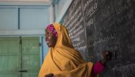 A young girl smiles as she looks back at her teacher for help answering a question during a class at her Unicef-supported primary school, Salaama, in Galkayo, Somalia, in this picture taken on April 12, 2017.