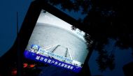 A screen broadcasts a CCTV state media news bulletin, showing an image of Mars taken by Chinese Mars rover Zhurong as part of the Tianwen-1 mission, in Beijing, China, May 19, 2021. REUTERS/Thomas Peter/File Photo/File Photo