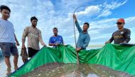 Local fishermen stand with a rescued 180-kilogram and 4-meter long giant freshwater stingray hooked by a fisherman's net at the Mekong River, in Stung Treng province, Cambodia May 5, 2022. Picture taken May 5, 2022. University of Nevada/Handout via REUTERS