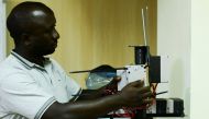 Joel Ssematimba, a hardware developer at a low-cost air quality monitoring dubbed AirQo checks new devices undergoing calibration inside a workshop at the Makerere University in Kampala, Uganda May 27, 2022. Picture taken May 27, 2022. REUTERS/Abubaker Lubowa