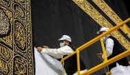 Workers wearing protective face masks work on raising the Kiswa, a silk cloth covering the Holy Kaaba, before the annual pilgrimage season, at the Grand Mosque in Mecca, Saudi Arabia July 22, 2020.