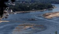 A ferry cruises past the partially dried riverbed of the Rhine river in Bingen, Germany, August 9, 2022. REUTERS/Wolfgang Rattay