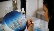 Paraguayan artist Lili Cantero, 29, paints a soccer ball with the skyline of Doha, Qatar, ahead of the 2022 FIFA World Cup, in San Lorenzo, Paraguay October 15, 2022. REUTERS/Cesar Olmedo