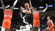 Milwaukee Bucks guard Grayson Allen (12) takes a shot against Oklahoma City Thunder guard Shai Gilgeous-Alexander (2), left and forward Jalen Williams (8) in the second quarter at Fiserv Forum. Michael McLoone