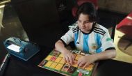 Sebastian Filoramo, 12, a visually impaired boy who adapted the FIFA World Cup Qatar 2022 Panini card album to Braille, checks his album in Barquisimeto, Venezuela, November 8, 2022. REUTERS/Keren Torres 