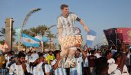 Argentina fans display a cut out of Lionel Messi during a march towards the Count Down Clock at the Doha Corniche. REUTERS