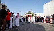 Bahrainis queue in front of a polling station on the island of Muharraq, north of the capital Manama, during parliamentary elections, on November 12, 2022. (AFP)