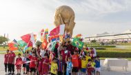 Young fans wave flags outside Al Bayt Stadium. Reuters