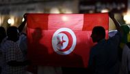 Fans of Tunisia hold up the national flag in support of the country in Doha on November 13, 2022, ahead of the Qatar 2022 World Cup football tournament. (Photo by Gabriel Bouys / AFP)