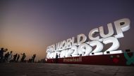 People take photos of the FIFA World Cup Qatar 2022 sign on the Doha Corniche on November 14, 2022. (AFP/Andrej Isakovic)