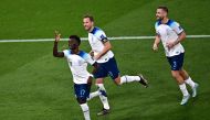 England's forward Bukayo Saka (left) celebrates teammates Harry Kane (centre) and England's defender #03 Luke Shaw after he scored England's fourth goal during the Qatar 2022 World Cup Group B football match between England and Iran at the Khalifa International Stadium in Doha on November 21, 2022. (Photo by Anne-Christine POUJOULAT / AFP)