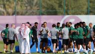 Saudi Arabia's French coach Herve Renard (centre) speaks with his players during a training session at the Sealine Training Site on November 21, 2022. (AFP/Khaled Desouki)