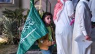 A young Saudi football fan walks with her country's flag during celebrations of Saudi Arabia's win over Argentina in the Qatar 2022 World Cup in the capital Riyadh on November 22, 2022. (Photo by AFP)