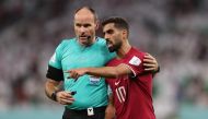 Qatar's Hassan Al-Haydos with referee Antonio Mateu Lahoz during World Cup Qatar 2022 match between Qatar and Senegal at Al Thumama Stadium on November 25, 2022. (REUTERS/Matthew Childs)