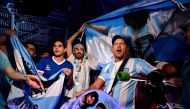 Fans of Argentina's Diego Maradona cheer as the pay tribute on the second anniversary of Maradona's death at a fan zone devoted to the Argentine at Doha's international airport on November 25, 2022. Photo by Javier Soriano / AFP