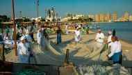 Participants prepare fishing nets during the Traditional Dhow Festival at Katara beach.