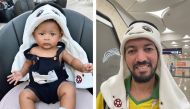 From left: Four month old T’kare Prince wearing a La’eeb plush hat and Abdulkaram from Algeria proudly wearing a La’eeb plush hat.