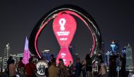 People take pictures in front of the Fifa countdown clock at the Corniche promenade in Doha on December 3, 2022, during the Qatar 2022 World Cup football tournament. (Photo by Jung Yeon-je / AFP)